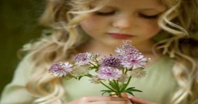 menina olhando para a flor