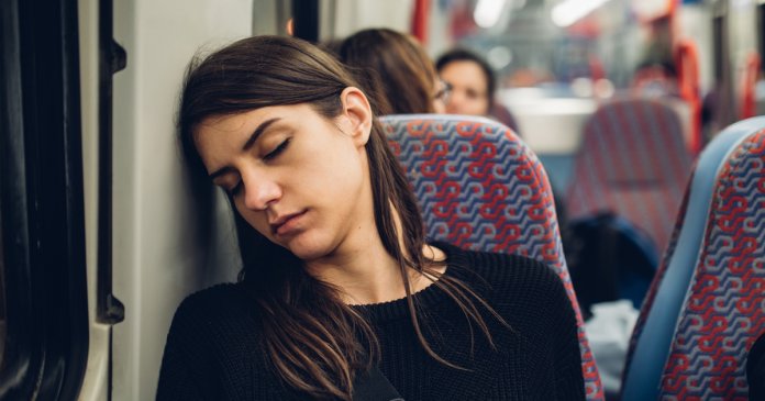 Passenger woman sitting in her seat and sleeping inside a train/